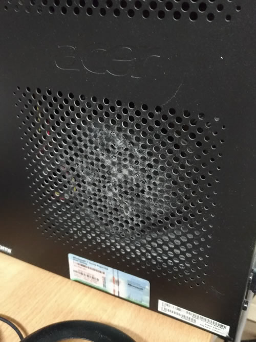 Fianco del computer in corrispondenza con la ventola del dissipatore della CPU con evidente deposito di polvere e lanuggine